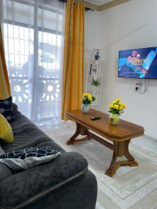 a living room with a couch and a coffee table at Ngoki’s comfort apartment in Mombasa