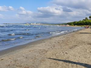 einen Strand mit Menschen und dem Meer an einem wolkigen Tag in der Unterkunft Casa Vacanze Cuore di Maremma in Il Bagno