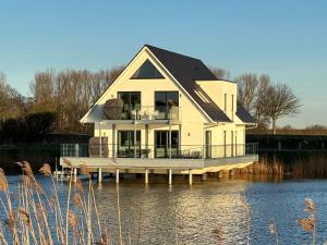 a large house on a dock on the water at Seeperle Meerleben in Carolinensiel