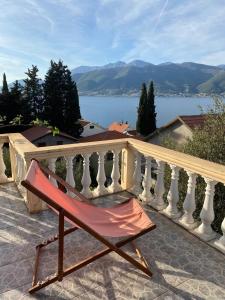 a chair on a balcony with a view of the water at Apartments Arina in Krasici