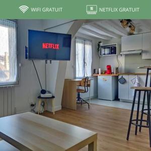 ein Wohnzimmer mit einem Netflix-Schild an der Wand in der Unterkunft Au p'tit Lagny - rue piétonne in Lagny