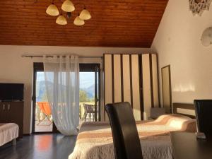 a bedroom with two beds and a balcony with a view at Apartments Arina in Krasici