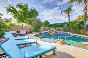 a backyard with a swimming pool with blue chairs at Upscale Tempe Home with Heated Saltwater Pool and BBQ in Tempe