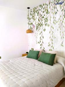 ein Schlafzimmer mit einem großen weißen Bett mit grünen Kissen in der Unterkunft Casa Rístori Fábrica de Harinas in Manzanares