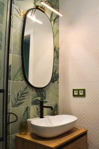 un bagno con lavandino e specchio di Casa Rístori Fábrica de Harinas a Manzanares