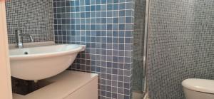 a blue tiled bathroom with a sink and a toilet at Maison Michela Sorrento in Sorrento