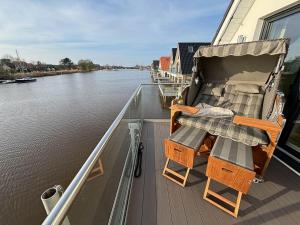 a deck with a table and chairs on a boat at Seeperle Meerleben in Carolinensiel