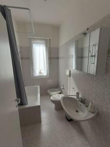uma casa de banho com um lavatório, um WC e um espelho. em Flori's Home em Bérgamo