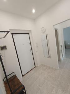 ein weißes Zimmer mit einer Tür und einem Stuhl darin in der Unterkunft Flori's Home in Bergamo