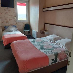 um quarto com 2 camas, uma janela e uma cadeira em Cap'tain Cook em Caurel