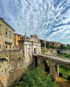 eine Steinbrücke mit einem Gebäude darüber in der Unterkunft Flori's Home in Bergamo