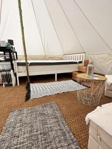 a room with a mattress in a tent with two rugs at Spacious bell Tent at Herigerbi Park Lincolnshire in Grantham