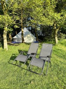 uma mesa e cadeiras sentadas na relva com uma tenda em Spacious bell Tent at Herigerbi Park Lincolnshire em Grantham