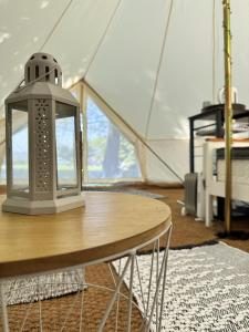 a table with a lantern on top of a tent at Spacious bell Tent at Herigerbi Park Lincolnshire in Grantham
