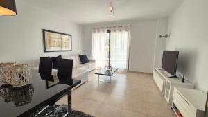 un soggiorno con divano bianco e TV di Apartamento en Los Monteros a Marbella