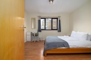 a bedroom with a bed and a window and a desk at GuestReady - 4BR Home in Surrey Quays Canada Water in London