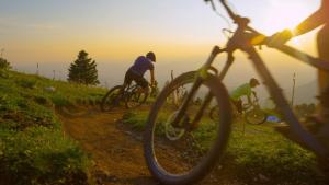 two people riding bikes on a dirt trail at sunset at Chalet BERGgrün Willingen in Willingen