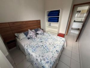 a small bedroom with a bed and an open closet at Apto dos Cardeais in Praia Grande