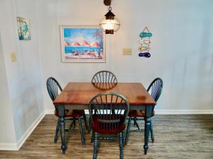 a dining room table with chairs and a painting on the wall at 35B GCR Everything Zen A Quiet Escape in Myrtle Beach