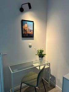 a glass desk with a chair and a picture on the wall at Mikro Aparty bezpłatny parking in Wrocław