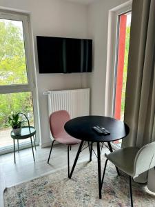 a living room with a table and chairs and a tv at Mikro Aparty bezpłatny parking in Wrocław