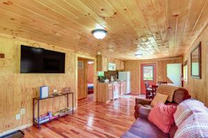 sala de estar con sofá y TV de pantalla plana en Serene Beattyville Cabin 24 Mi to Red River Gorge en Beattyville