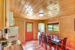 cocina con mesa con sillas y puerta roja en Serene Beattyville Cabin 24 Mi to Red River Gorge en Beattyville
