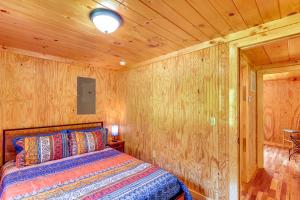 1 dormitorio con 1 cama en una pared de madera en Serene Beattyville Cabin 24 Mi to Red River Gorge en Beattyville