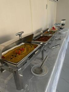 una fila de bandejas de comida en una mesa en Lina Dreamland Resort, en Billah