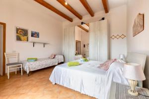 a bedroom with two beds and a chair in it at Tenuta Ponte Vecchio in Bortigiadas
