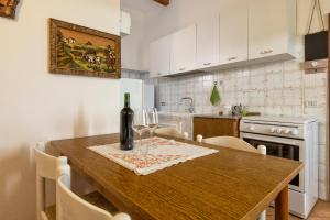 a kitchen with a wooden table with a bottle of wine at Tenuta Ponte Vecchio in Bortigiadas