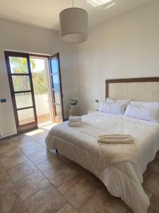 a bedroom with a large bed and a large window at Casa Le Radici-Castro in Castro di Lecce