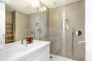 a bathroom with a white sink and a shower at WHome Top Floor w Luxury Design Premium Location in Lisbon +8 photos