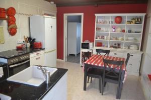 cocina con armarios blancos, mesa y sillas en La Casina de Luarca, en Luarca