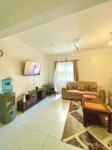 a living room with a couch and a tv at Pazuri Homes 2BD Apartment in Mombasa