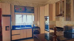 a kitchen with a sink and a stove top oven at DreamWest Living The Guesthouse in Krugersdorp