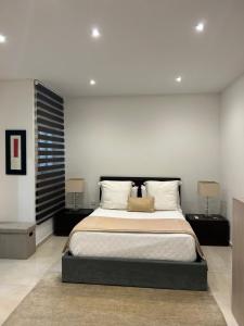 ein Schlafzimmer mit einem großen Bett mit zwei Nachttischen in der Unterkunft Spacious Luxury 3 bedroom apartment - Southridge - Mellieha in Mellieħa