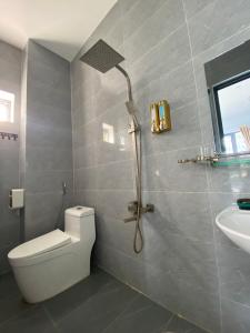 uma casa de banho com um chuveiro, um WC e um lavatório. em Hotel Vũng Găng em Vinh Hy