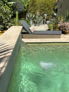 una piscina con una fuente de agua en un patio en un petit coin de paradis avec piscine et parking, en Villeneuve-lès-Avignon