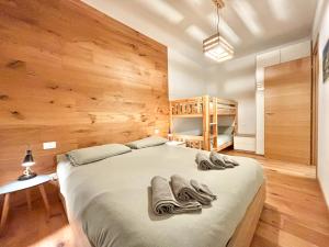 1 dormitorio con 1 cama grande y paredes de madera en Moderno TRILOCALE vicino alle piste en San Pietro