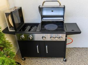 a black barbecue grill with a fan and a grill at AYASI Luxury Apartment Predeal in Predeal