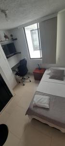 una camera con 2 letti, una scrivania e una sedia di habitación con baño en bucaramanga-cerca sena-uis a Bucaramanga