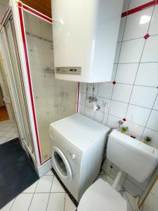 uma máquina de lavar e secar roupa numa pequena casa de banho em Moderne Ferienwohnung Felbbauer #50 em Knittelfeld