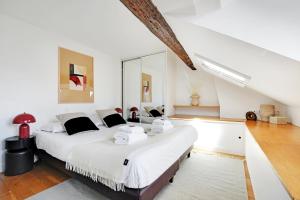a bedroom with a large bed with white sheets at Residence central marais in Paris