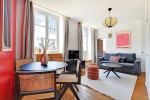 a living room with a table and a couch at Residence central marais in Paris