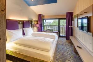 um quarto de hotel com duas camas e uma televisão em Explorer Hotel Bad Kleinkirchheim em Bad Kleinkirchheim
