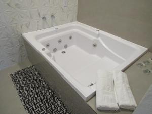 a white bath tub in a bathroom with towels at Pousada Meraki in Serra do Cipo +71 photos