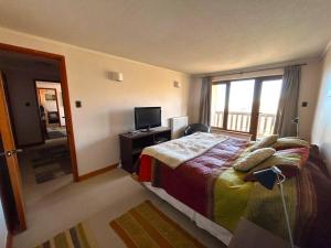 - une chambre avec un lit, une télévision et un balcon dans l'établissement Apartamento Valle de la Luna 502 - VALLE NEVADO, à Santiago