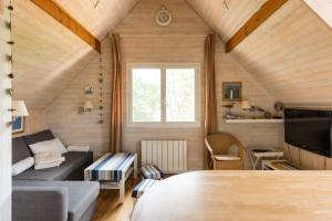 ein kleines Wohnzimmer mit einem Sofa und einem TV in der Unterkunft Appartement 2 chambres Bassin d'Arcachon front de mer, plage du Betey in Andernos-les-Bains