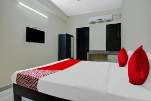 ニューデリーにあるOYO Flagship Hotel B K Palaceのベッドルーム(白いベッド、赤い枕付)